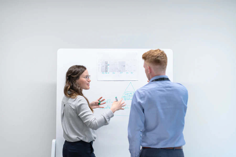 Colleagues discussing a diagram at a whiteboard